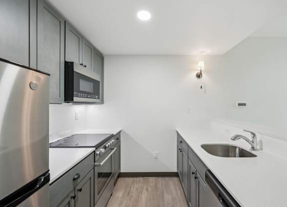 A modern kitchen with stainless steel appliances and a white countertop.