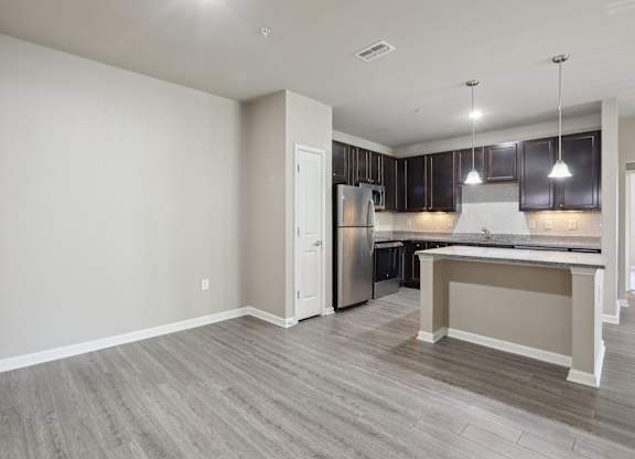 Model kitchen with a refrigerator, cabinets, and a countertop.