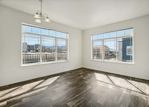Model Living Room with Wood-Style Flooring and Window Views at Altitude on Fifth Apartments located in Salt Lake City, UT.