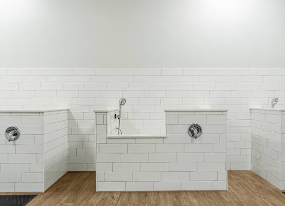 A white tiled bathroom with two sinks and a bathtub.