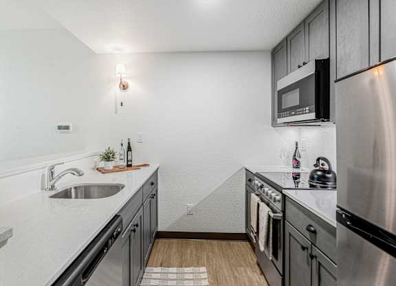 A modern kitchen with stainless steel appliances and a white countertop.