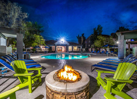a fire pit and pool at night at the resort at turf