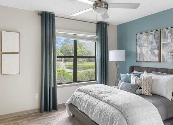 Model Bedroom with Wood-Style Flooring and Window View at Mirage on Kernan Apartments located in Jacksonville, FL.