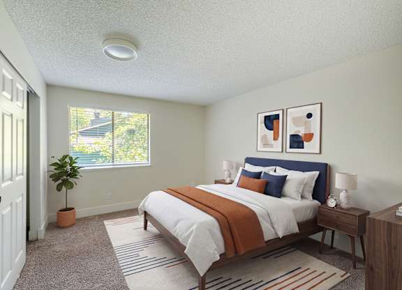 A bedroom with a bed, nightstand, and window.
