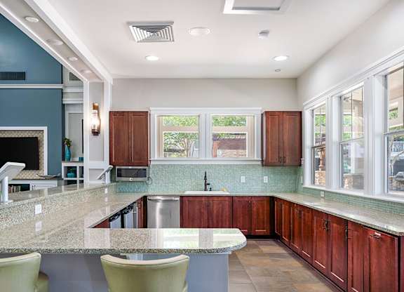 A kitchen with a marble countertop and wooden cabinets.
