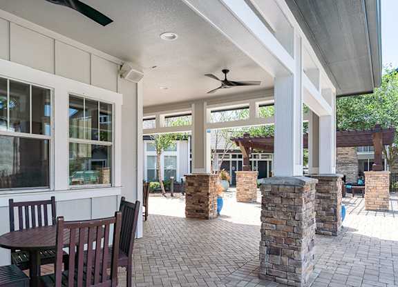 A patio with a table and chairs under a roof.