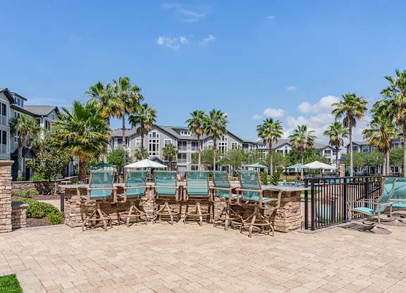 A patio with chairs and a table surrounded by a fence.