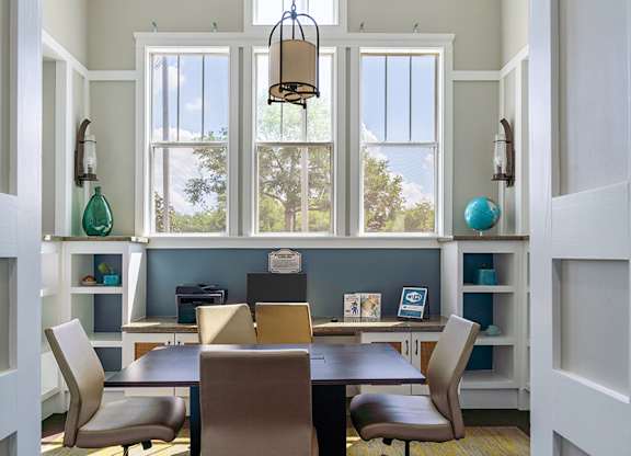 A dining room with a table and chairs.