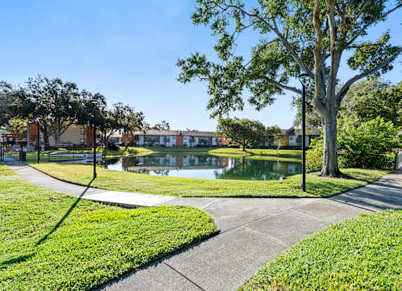 Community lake with concrete walking path at Bridges at Bayside in St. Petersburg, Florida.