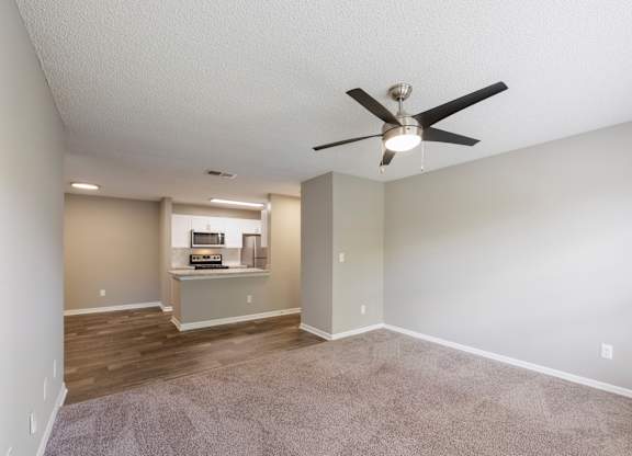 Model living room with ceiling fan and carpet at Fountains at Lee Vista in Orlando, Florida.