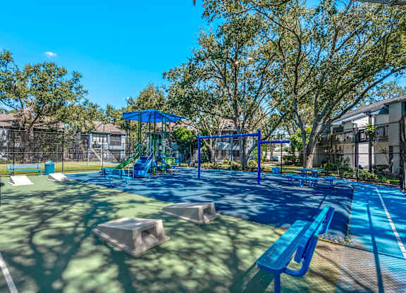 Community playground, benches, picnic tables and cornhole boards at Huntington Place in Sarasota, Florida.