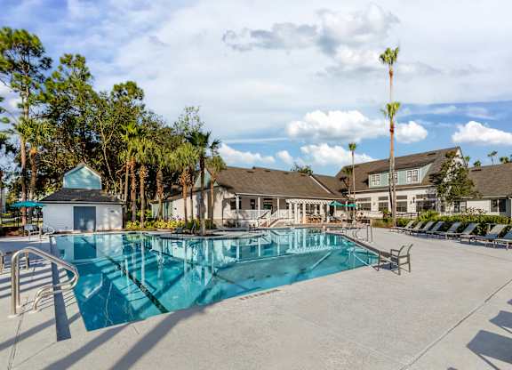 A swimming pool surrounded by trees and buildings.