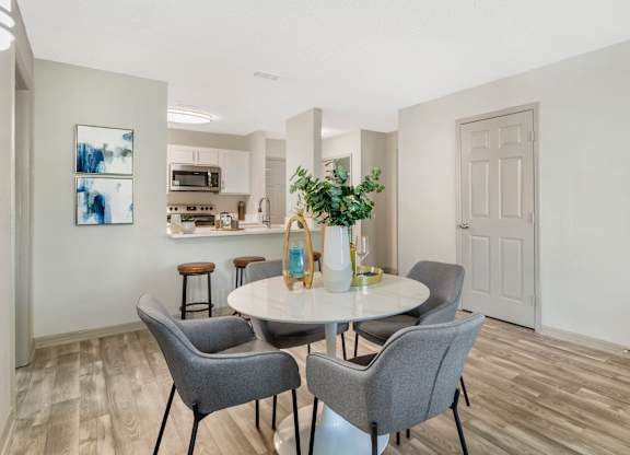 A dining room with a table and chairs.