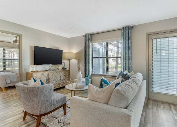 A living room with a grey couch, a chair, and a television.