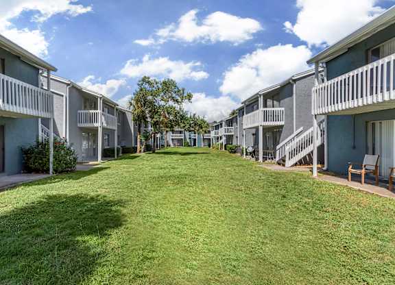 Community wide picture of garden style apartments with a large, green lawn at Park at 7200 in Jacksonville, Florida.