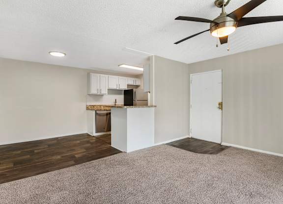 Model living room with ceiling fan, carpeted and at Park at 7200 in Jacksonville, Florida.