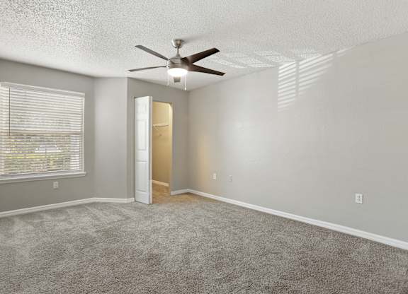 Model bedroom with carpeted floor and a ceiling fan at Hunters Green in Tampa, Florida.