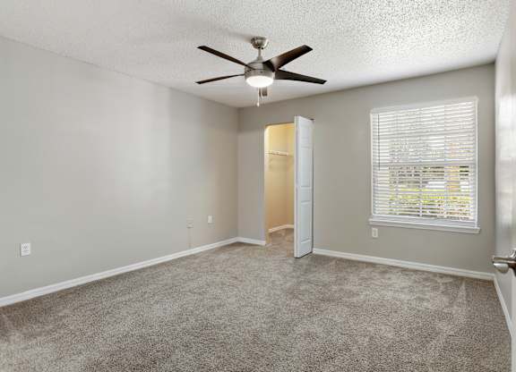 Model bedroom with carpet and and a ceiling fan at Hunters Green in Tampa, Florida.