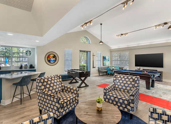 A living room with a pool table and a television.