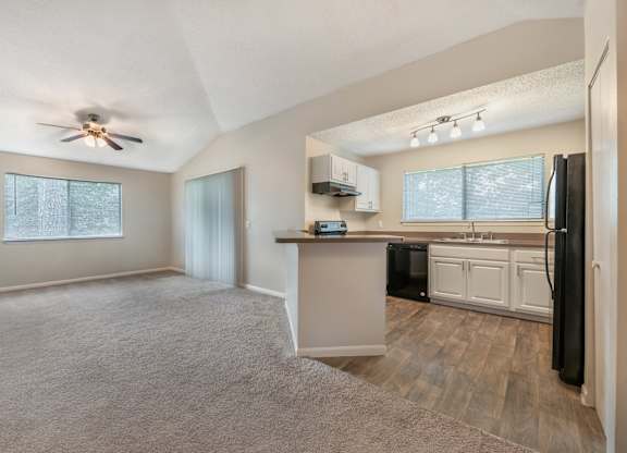 A spacious kitchen with a refrigerator, sink, and cabinets.