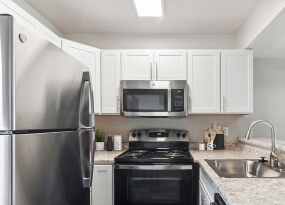 a kitchen with a stove top oven by a refrigerator