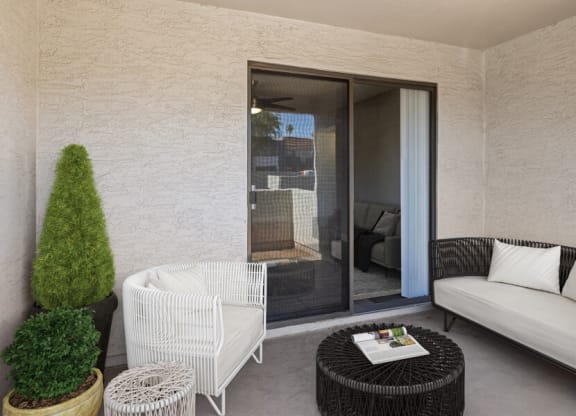 a patio with a white couch and a black coffee table