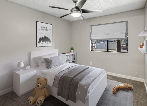 a bedroom with a ceiling fan and a window with a blind