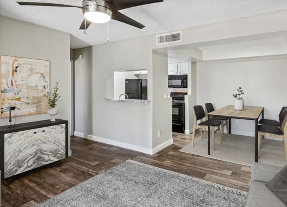 a living and dining area with a ceiling fan and hardwood floors