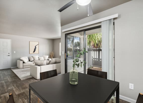 a dining area with a table and chairs and a living room with a couch and a door