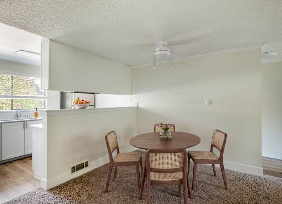 A dining room with a round table and chairs.