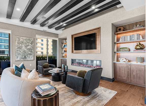 Community Clubhouse with Lounge Furniture, TV and Fireplace at Ovation at Galatyn Park Apartments located in Richardson, TX.