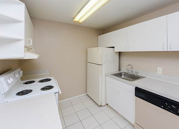 A small kitchen with a white stove and a white dishwasher.