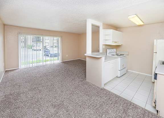 A kitchen area with a white fridge, stove, and microwave.