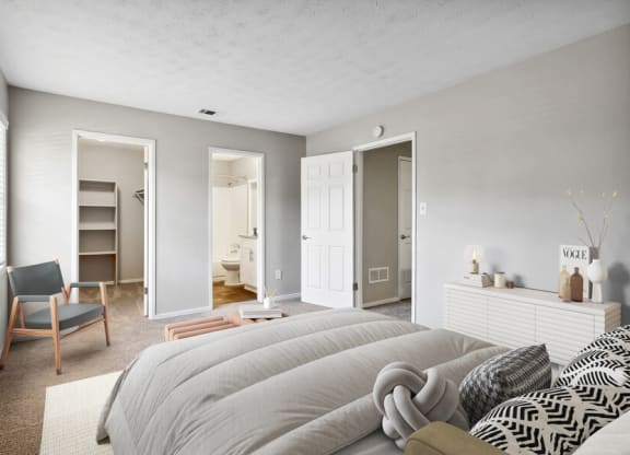 Model apartment bedroom with a large bed and a closet