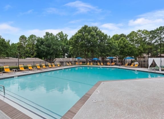 2-Bedroom Apartments in Norcross, GA - Elevate at Jackson Creek - Relaxing Outdoor Pool With Wide Sundeck, Lounge Chairs, and Umbrella Seating