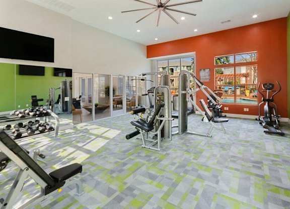 Apartments in Garland, TX, with In-Unit Washer and Dryer - The Belmont at Duck Creek - A Fitness Center With Weight Machines, Dumbbell Rack, And Stationary Bike.