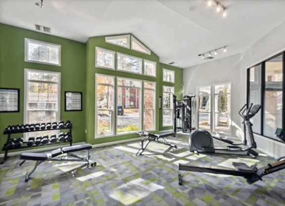 East Charlotte, NC, Apartments Near SouthPark Mall - Woodland Estates - A Fitness Center With Cardio Equipment, Free Weights, Workout Benches, Large Windows, And Green Accent Walls.