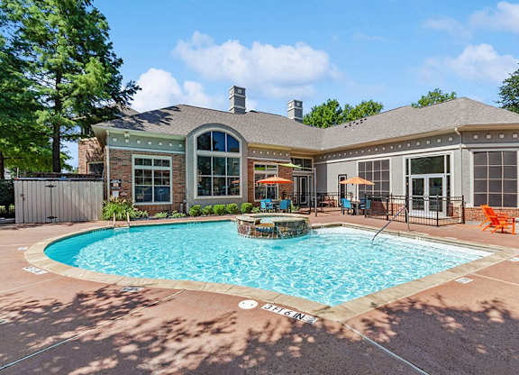 Garland, TX, Apartments with In-Unit Washer and Dryer - The Belmont at Duck Creek - A Swimming Pool With Central Spa Feature, Pool Deck Seating With Umbrellas, And Clubhouse.