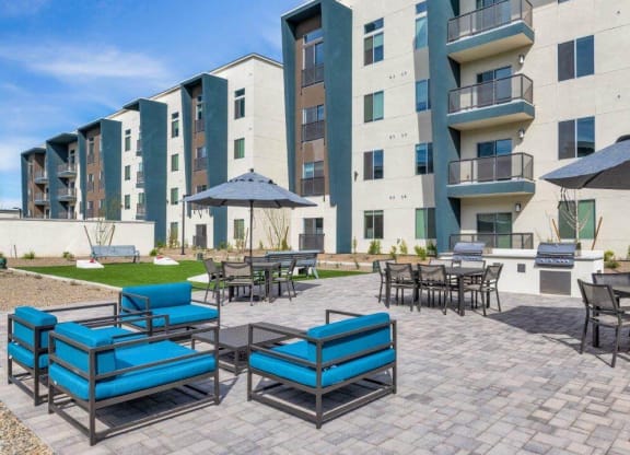 Patio lounge area with BBQ grills at Glen 91 Apartments in Glendale, AZ