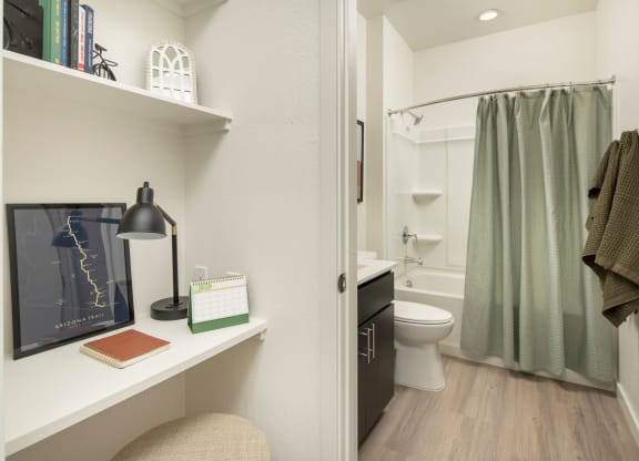 a bathroom with a white toilet next to a green shower curtain