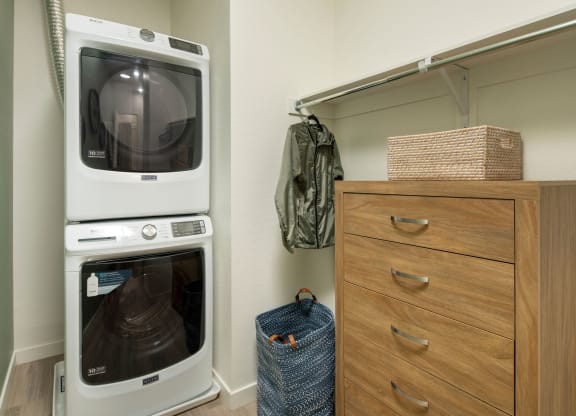 a washer and dryer sit next to a dresser in a laundry room