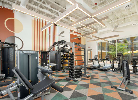 a view of the fitness center with a variety of exercise equipment