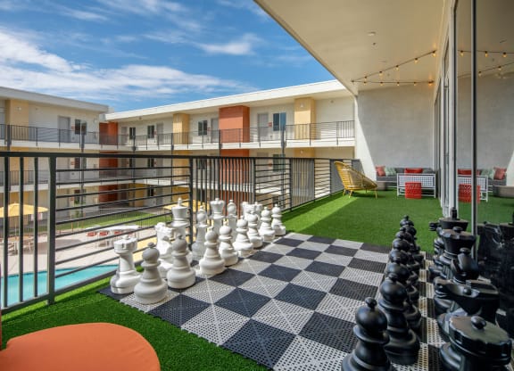 a large chess board on a balcony with a blue sky in the background