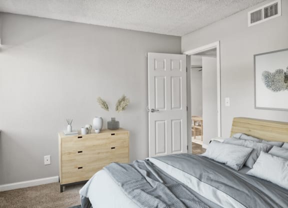 model apartment bedroom with a bed and dresser
