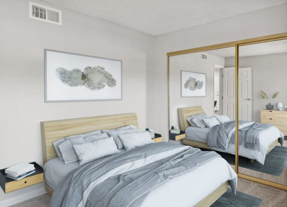 Model bedroom with a bed and a large mirror