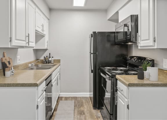 a kitchen with white cabinets and a black stove top oven