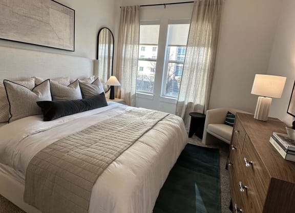 a bedroom with a bed and a dresser and a window