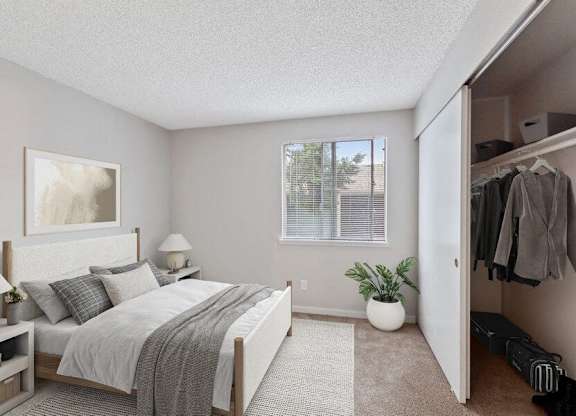 Pet-Friendly Apartments in Federal Way, WA - Sunset Three Twenty - A Bedroom With A White Bed With Gray Bedding, Two White Nightstands With Lamps, And A Window.