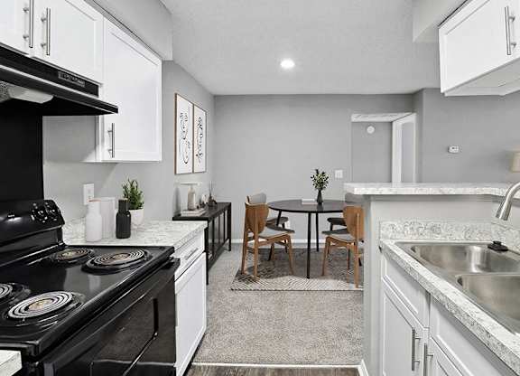 Model Kitchen with White Cabinets, Wood-Style Flooring and View of Dining Room at Abbington Heights Apartments in Antioch, TN.