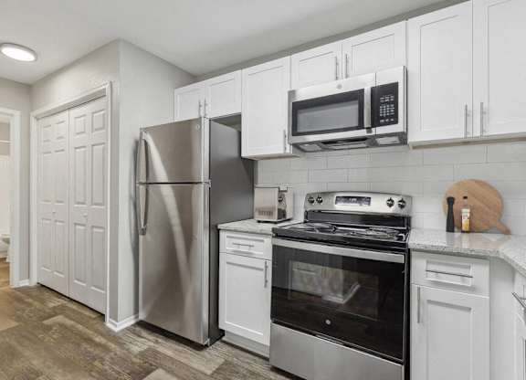 a kitchen with stainless steel appliances and white cabinets